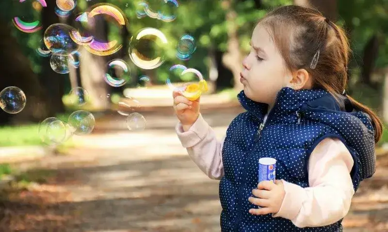 シャボン玉で遊ぶ女の子。