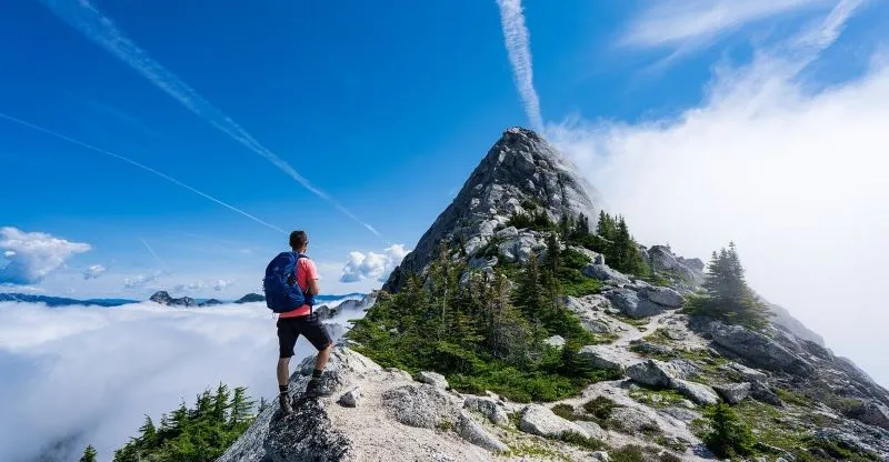 山の中腹で、山頂を仰ぎ見る登山者。